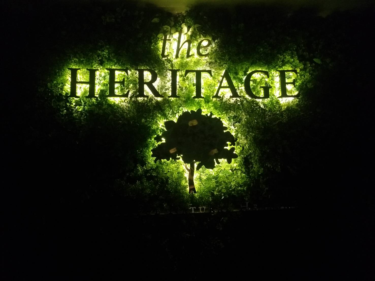 ป้ายโลโก้ สแตนเลสโรสโกลด์ ติดไฟออกหลัง ร้าน THE HERITAGE