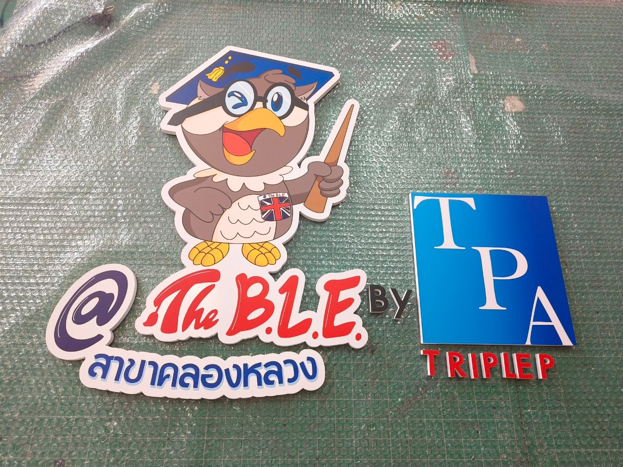 ป้ายพลาสวูดติดสติกเกอร์ '' @The B.L.E by TPA ''