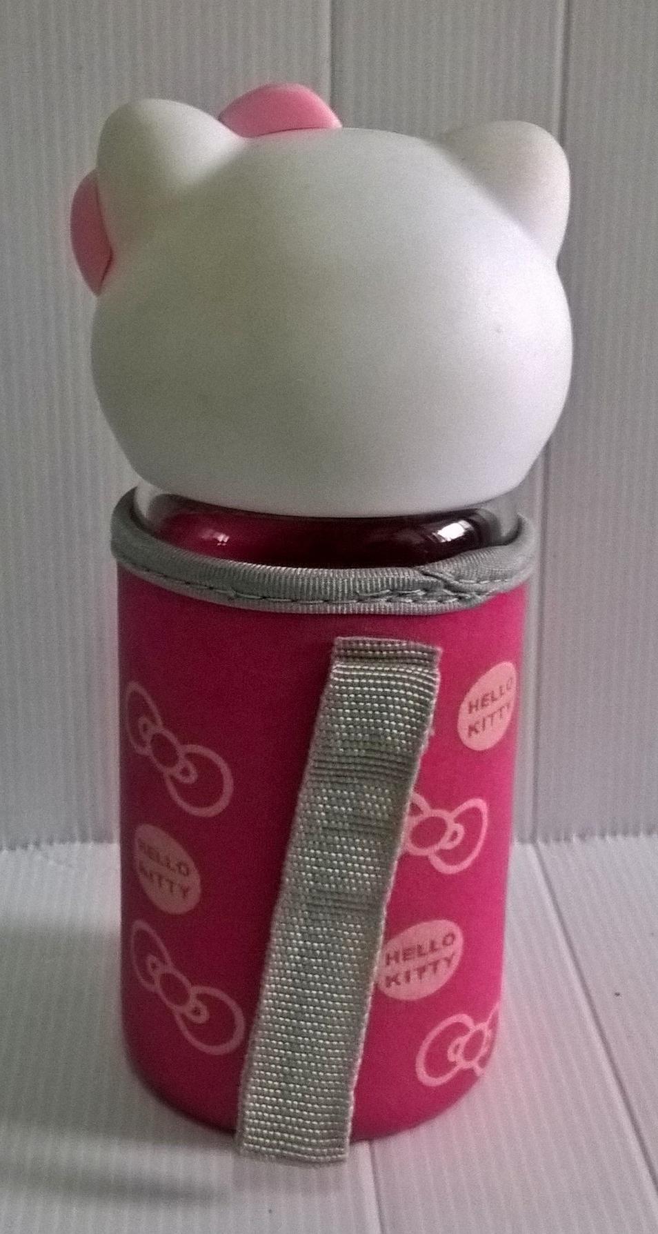 ขวดโหลแก้วใส ฝาขวดเป็นหัวคิตตี้ ถุงครอบขวดแก้วสีชมพูลายโบว์ และ Hello Kitty จาก Sanrio เส้นผ่าศุนย์กลางประมาณ 7 cm. สูงประมาณ 18 cm.