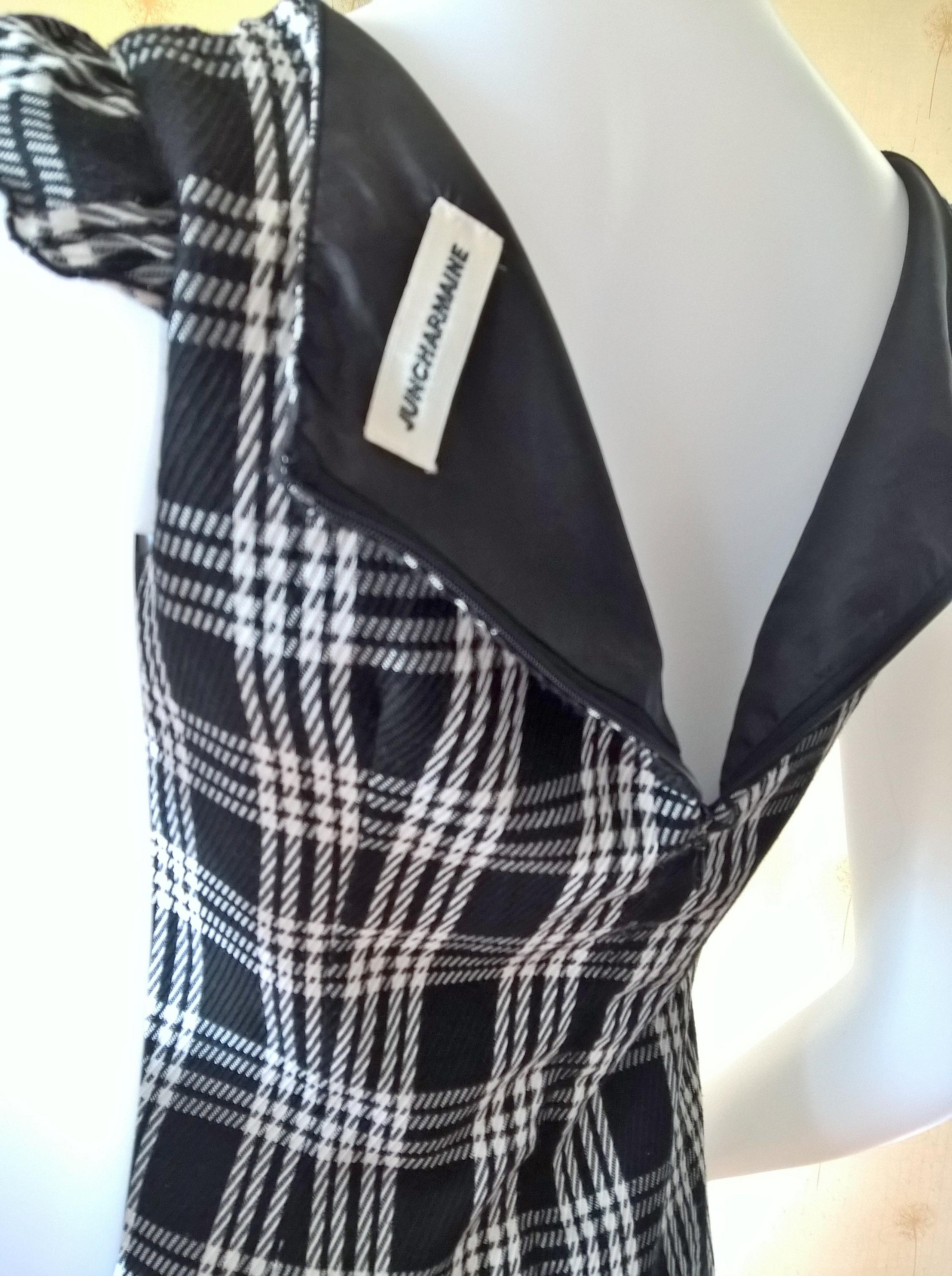 ชุดเดรส สีดำลายสก๊อต ผ้าทอ คอกว้าง แต่งรอบอกด้วยลูกไม้ดำ ผูกริบบิ้นดำเล็กตรงกลางหน้าอก มีซับในและติดซิปหลัง