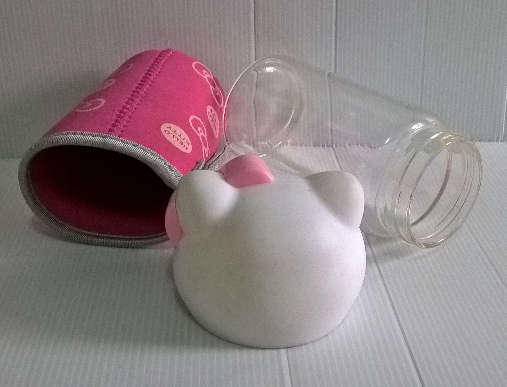 ขวดโหลแก้วใส ฝาขวดเป็นหัวคิตตี้ ถุงครอบขวดแก้วสีชมพูลายโบว์ และ Hello Kitty จาก Sanrio เส้นผ่าศุนย์กลางประมาณ 7 cm. สูงประมาณ 18 cm.