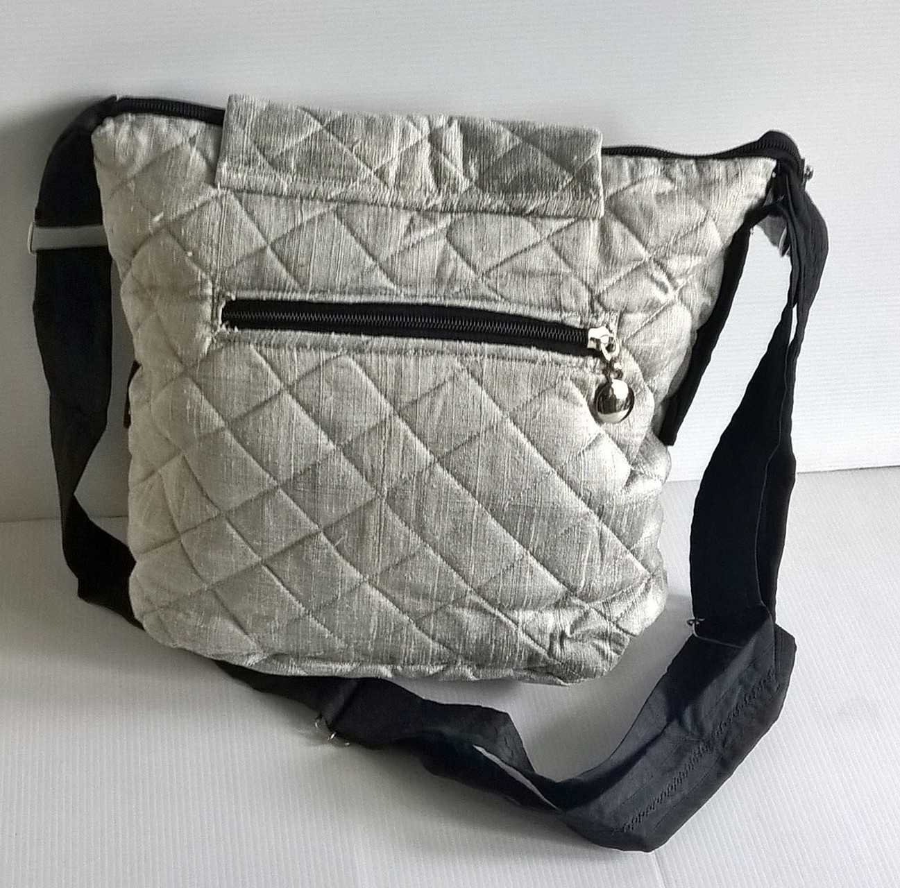 ขายกระเป๋าผ้าไหมไทยแท้งานแฮนเมดสีเทาเงิน สายผ้าดำปรับความยาวได้ ด้านหลังมีช่องกระเป๋าเล็กติดซิป มีซับในและช่องเล็กที่ผนังกระะเป๋า น้ำหนักเบา ราคาพิเศษ