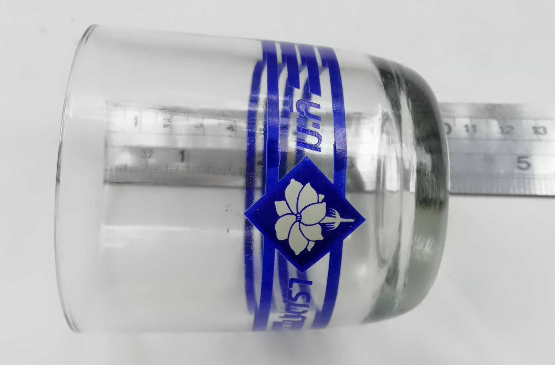 ของเก่าสะสม แก้วน้ำของสะสมจากนมตรามะลิ พิมพ์ลายเส้นสีน้ำเงินและโลกโก้นมรามะลิที่ด้านล่างของแก้ว เส้นผ่าศุนย์กลางประมาณ 7.5 cm. ความสูงประมาณ 8 cm.