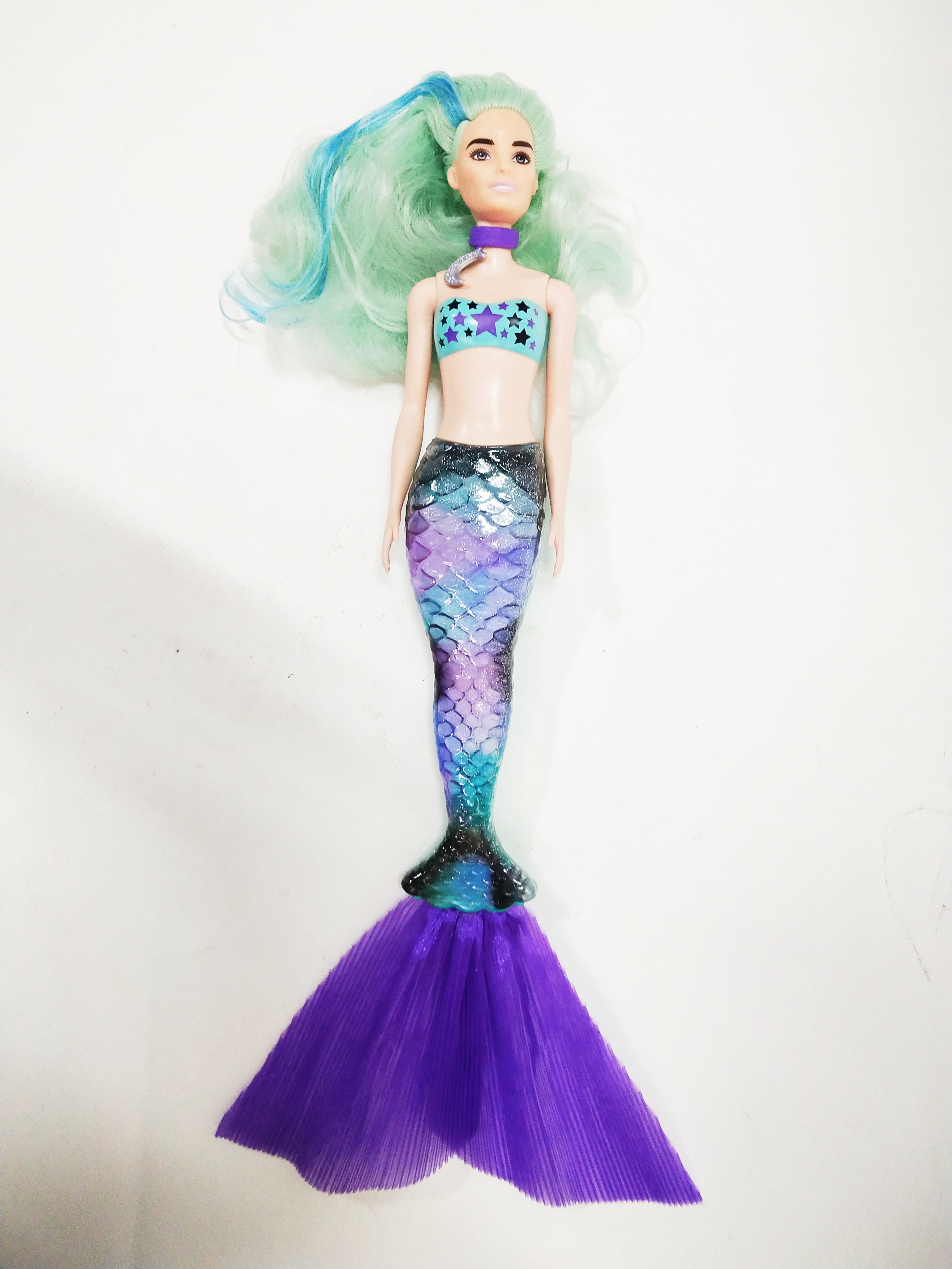 ตุ๊กตาบาร์บี้นางเงือกเปลี่ยนสี รุ่น Mattel Barbie Color Reveal Mermaid, สามารถเปลี่ยนหางกับหางของตัวอื่นๆใน Collection เดียวกันได้, บริเวณหน้าผากและเหลือคิ้วและสันจมูกเมื่อโดนน้ำเย็นจะเป็นลายตามภาพ , บริเวณผมตรงสีเข้มเมื่อโดนน้ำเย็นจะกลายเป็นสีม่วง
