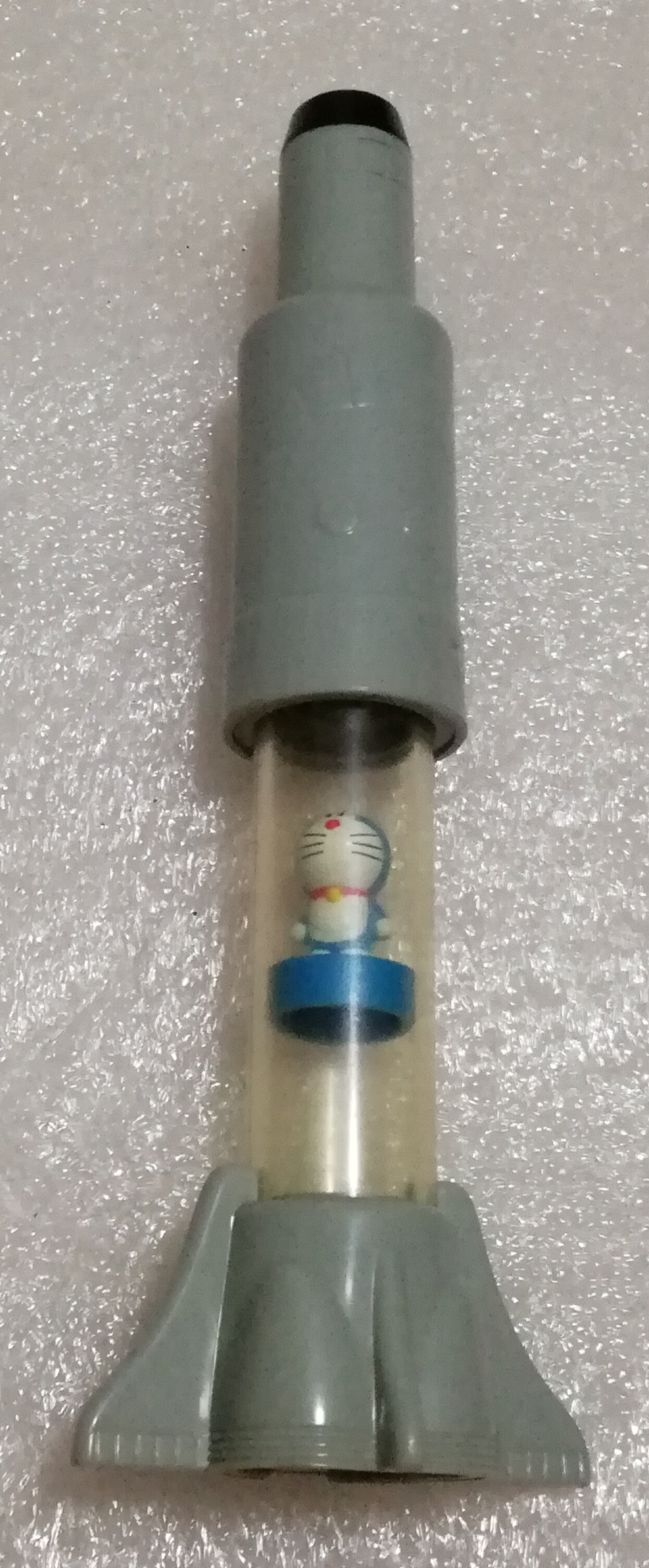 ของสะสมโดราเอม่อนในจรวด Doraemon เมื่อกดปุ่มบนหัวจรวด ลมที่เข้าด้านล่างจะดันตัวโดราเอม่อนให้ลอยขึ้นไปด้านบน