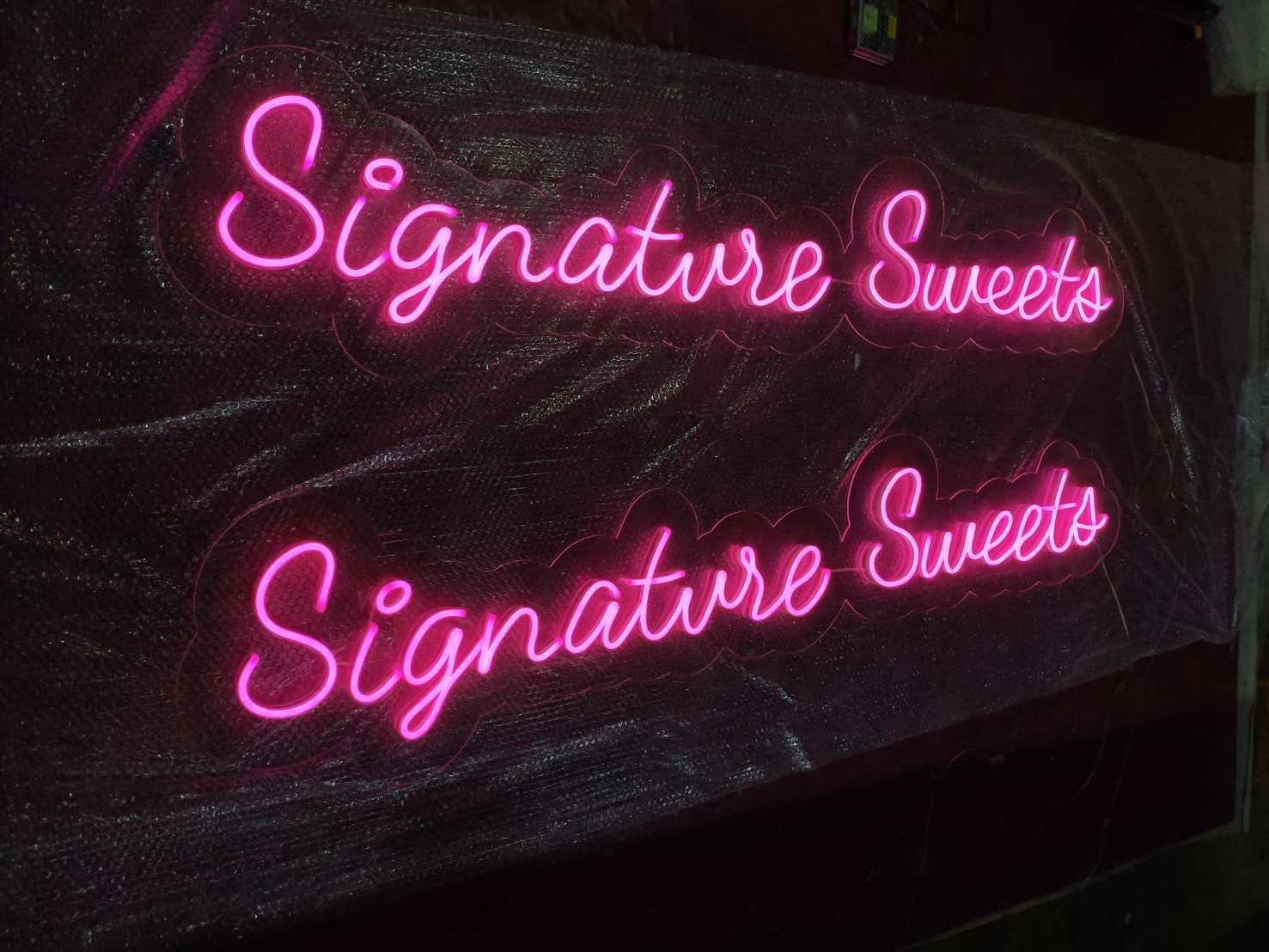 ป้ายไฟนีออนดัด วางบนอะคริลิค แสงสีชมพู - Signature sweets