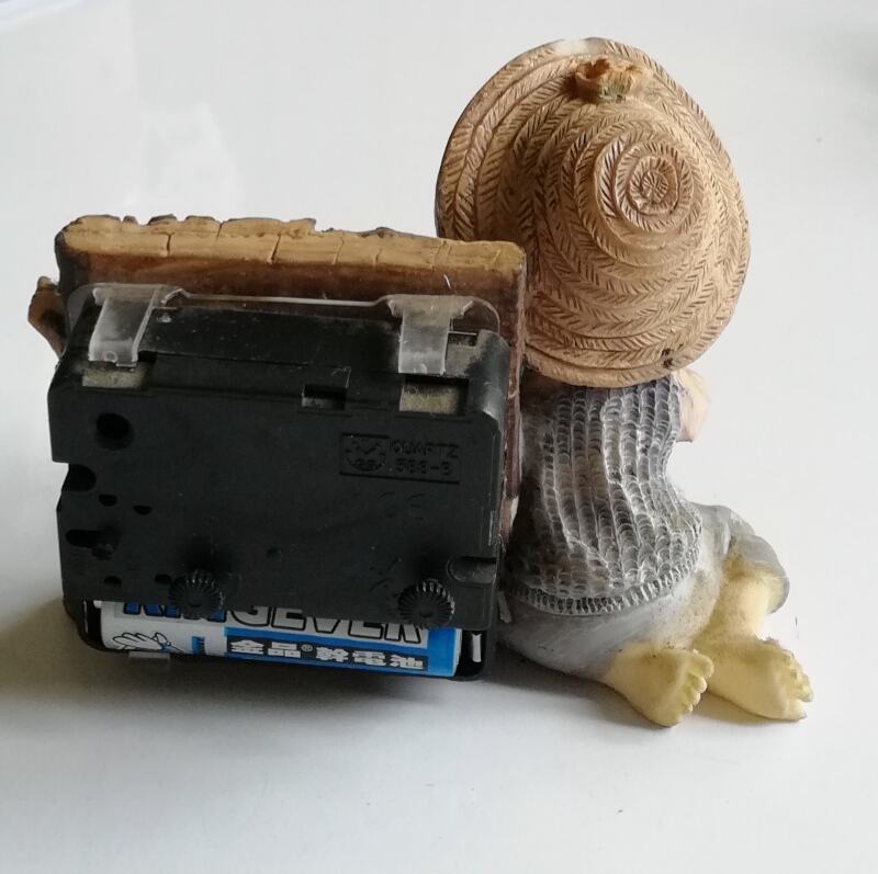 นาฬิกาปลุก รูปตุ๊กตาน่ารักพร้อมขอนไม้นาฬิกา ทำงานปกติ เครื่องนาฬิกาด้านหลังเคลื่อนได้เล็กน้อย ฝาถ่านเปลือย, Cutie Little Girl with a Log Vlock, work properly