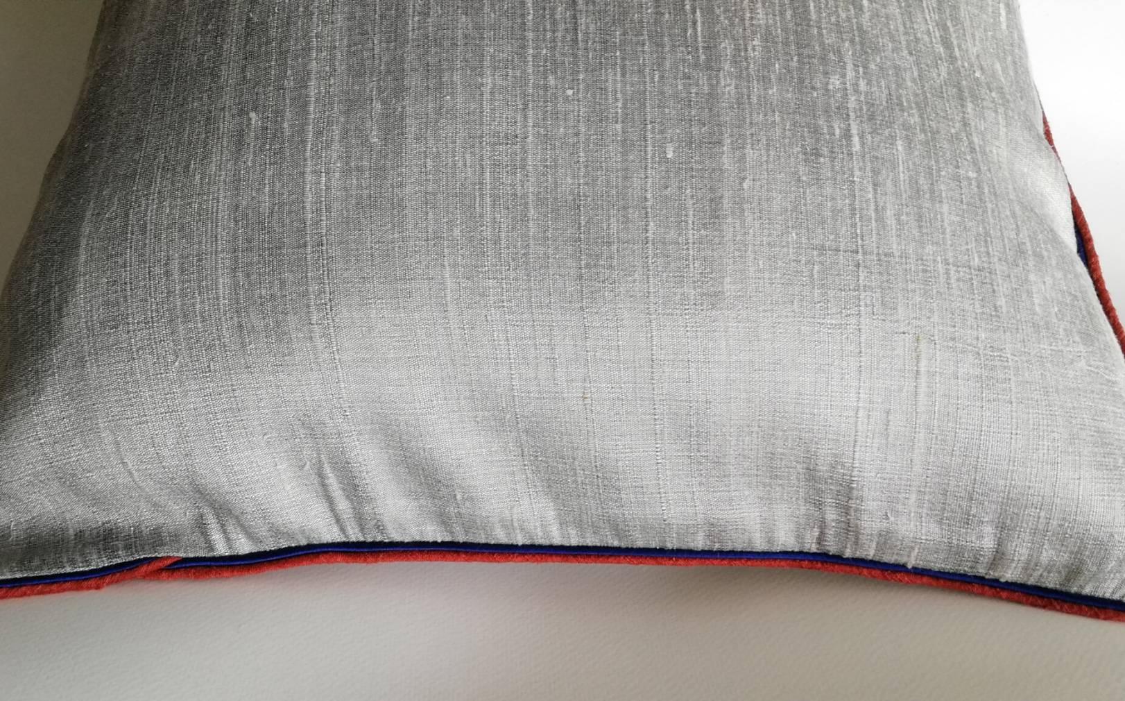 ปลอกหมอนอิงผ้าไหมไทยเท้2เส้น 16"*16" ของใหม่มีรอยเปื้อนเล็กน้อยตามภาพสุดท้าย เนื้อผ้าแบบมีเท็กเจอร์ เนื้อนุ่ม เย็น สีเทา แต่งกุ๊นขอบ2ชั้นด้วยสีแดงและสีน้ำเงิน ติดซิปซ่อน