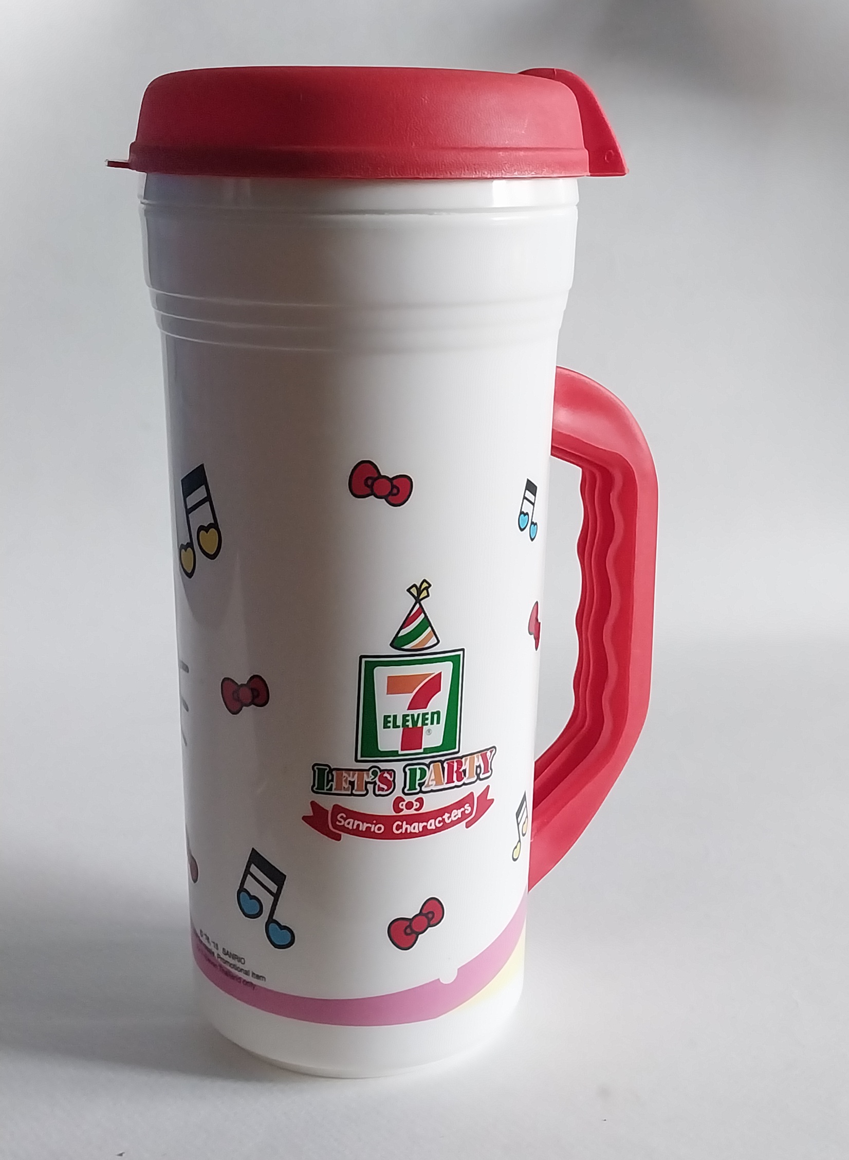 แก้วน้ำพลาสติกสีขาว แดงมีหูจับ ขนาดใหญ่ประมาณ 32 ออนซ์ ลายคิตตี้ใส่เสื้อ7-11 Hello Kitty จาก Sanrio ของสะสมจาก7-11