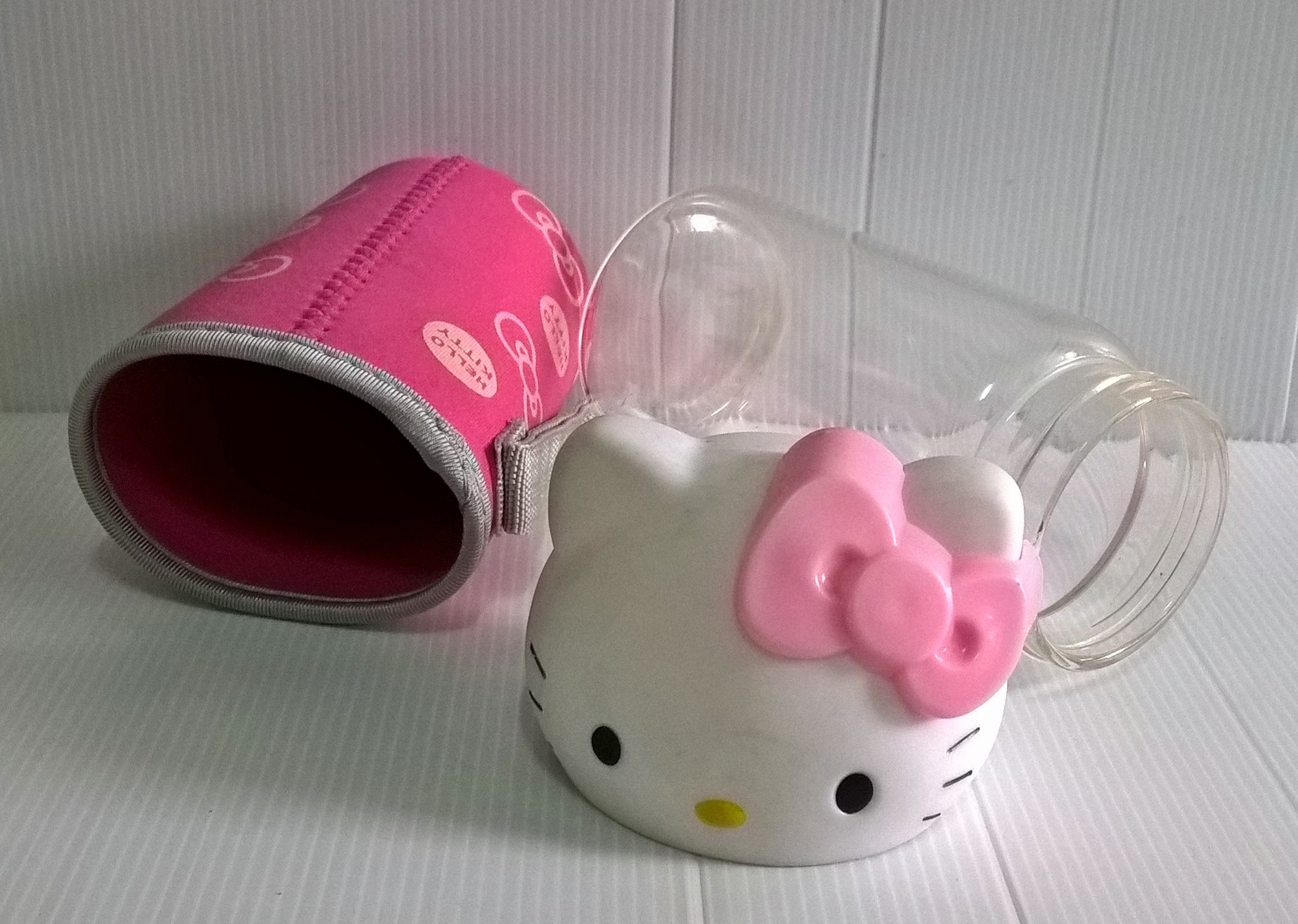 ขวดโหลแก้วใส ฝาขวดเป็นหัวคิตตี้ ถุงครอบขวดแก้วสีชมพูลายโบว์ และ Hello Kitty จาก Sanrio เส้นผ่าศุนย์กลางประมาณ 7 cm. สูงประมาณ 18 cm.