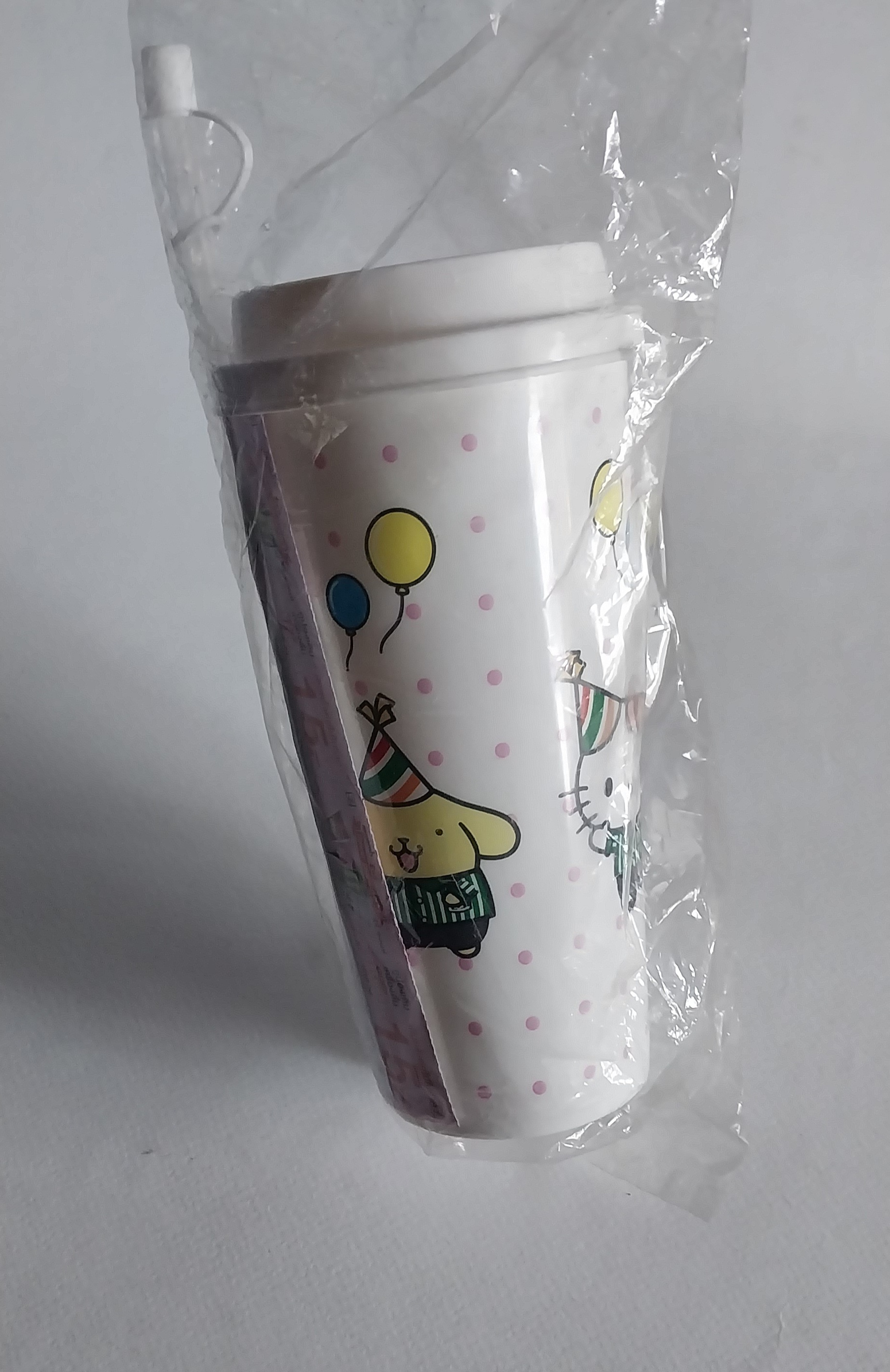 แก้วน้ำอัดลม ขนาดประมาณ 18 ออนซ์ ของสะสมจาก 7-11 Sanrio Collection สี ขาวลายจุดชมพู ลายรวมการ์ตูน Sanrioใส่เสื้อ 7-11 : คิตตี้ ,มายเมโลดี,กบเคโระ ,ปอมปอม ปุริน,แบตสึมารุ