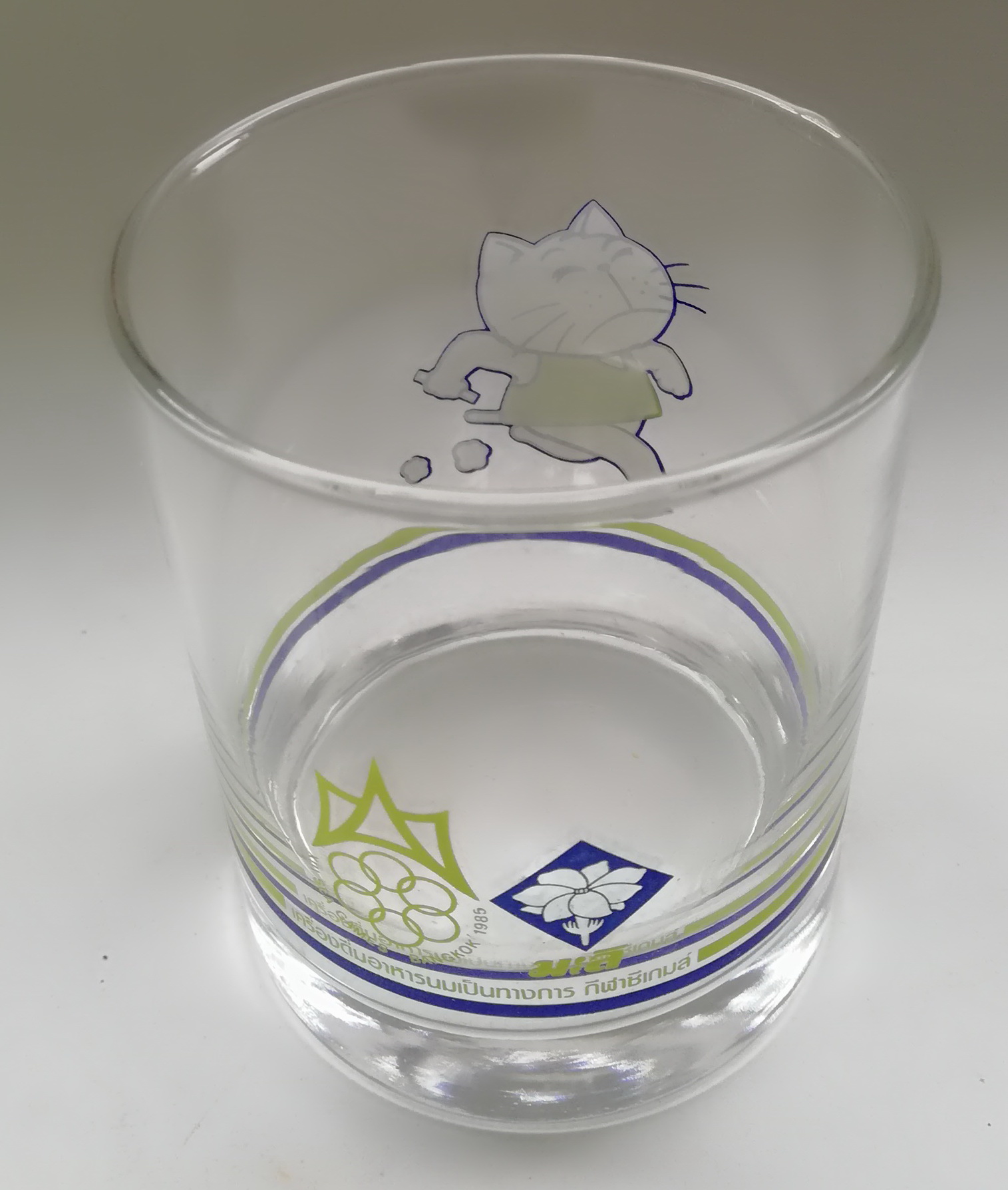 ของเก่าสะสม แก้วน้ำของสะสมจากนมตรามะลิ เครื่องดื่มอาหารนมเป็นทางการ กีฬาซีเกมส์ SEA GAMES BANGKOK 1985 ลายแมวใส่เสื้อสีเขียววิ่ง เส้นผ่าศุนย์กลางประมาณ 7.5 cm. ความสูงประมาณ 9 cm.