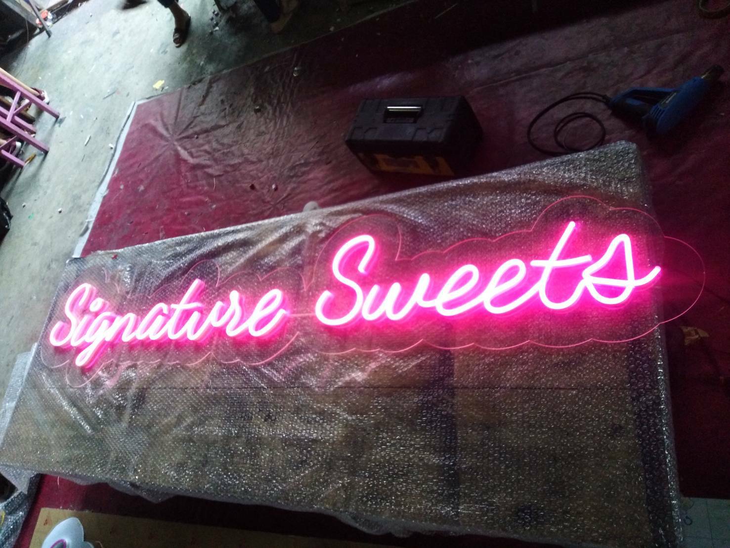 ป้ายไฟนีออนดัด วางบนอะคริลิค แสงสีชมพู - Signature sweets