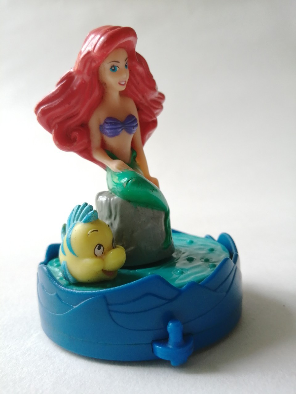 ของสะสมเจ้าหญิงเงือกน้อย The Little Mernaid, Arial แอเรี่ยล จากดิสนีย์ ฟิกเกอร์ แอเรี่ยลนั่งบนโขดหิน มีปลาว่ายน้ำหมุนรอบแอเรี่ยล ด้านล่างเป็นล้อ เมื่อเข็นล้อ น้ำและปลาจะหมุน**ระบบลานเก่า หมุนไม่ค่อยไป ใช้มือจับปลาหมุนแทนได้ ***ช่วงหัวเข่าแอเรี่ยลสีลอกเล็ก
