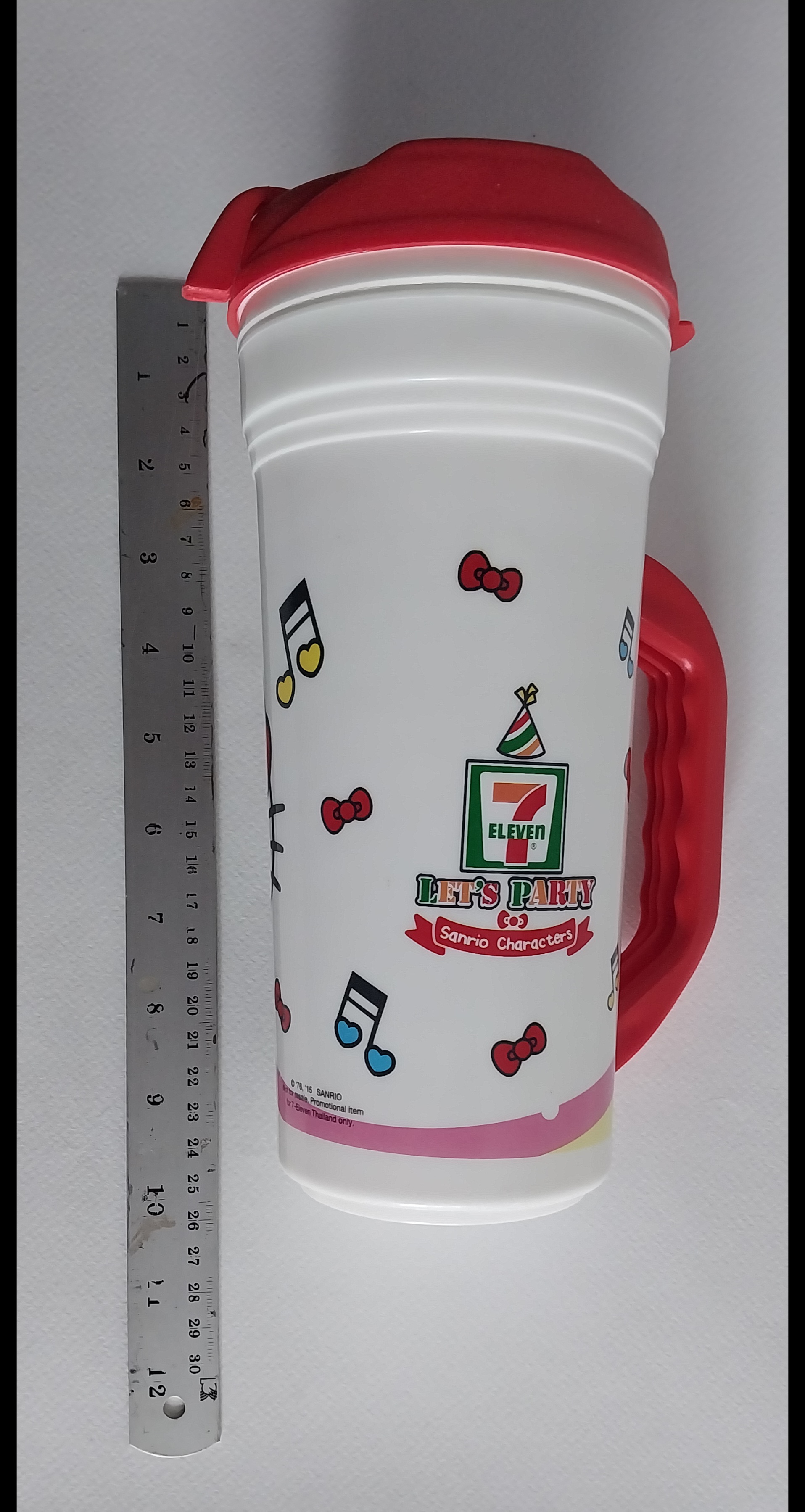 แก้วน้ำพลาสติกสีขาว แดงมีหูจับ ขนาดใหญ่ประมาณ 32 ออนซ์ ลายคิตตี้ใส่เสื้อ7-11 Hello Kitty จาก Sanrio ของสะสมจาก7-11