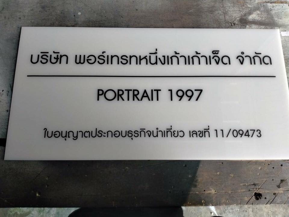 ป้ายอะคริลิค ติดสติ๊กเกอร์ตัวอักษร บริษัท พอร์เทรทหนึ่งเก้าเก้าเจ็ค จำกัด PORTRAIT 1997 ใบอนุญาตประกอบธรุกิจนำเที่ยว เลขที่11/09473