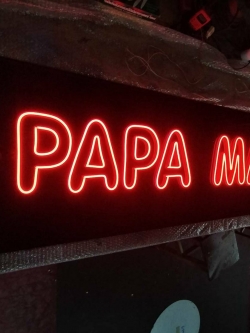 ป้ายไฟ LED ดัด - PAPA MAN วางบนอคลิคิกสีดำ