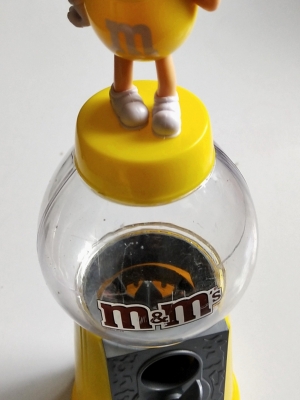 ของสะสม ตู้ไขขนมM&M ตัวสีเหลือง ยืนเท้าสะเอว และโบกมือ เปืดฝาใส่ขนม และไขขนมได้ปกติ